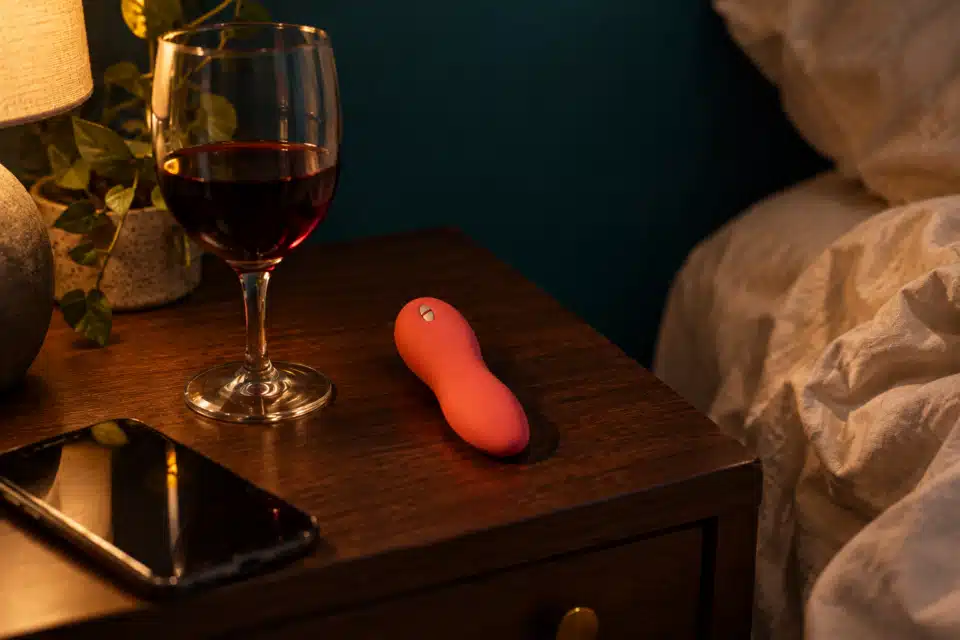 Coral clitoral vibrator on nightstand